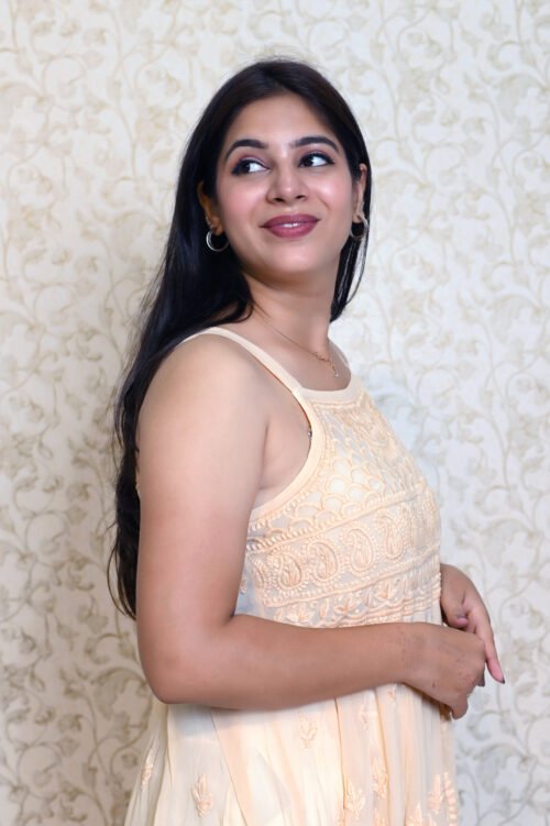 "Elegant sleeveless gown featuring intricate white chikankari embroidery on lightweight fabric, perfect for festive or formal occasions."